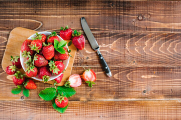 Wall Mural - Ripe sweet strawberries in white plate on the wooden background. Copy space