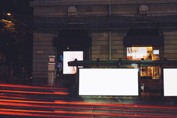 Bus station billboards with blank copy space screens for advertising text message or promotional content, empty mock up Lightbox for information, bus stop shelter clear display in city street at night