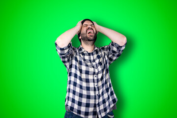 Wall Mural - Portrait of a puzzled bearded man holding hands on his head isolated over chroma background