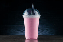 Cherry Milkshake In Plastic Glass On A Dark Background. Cherry Milkshake In Takeaway Cup