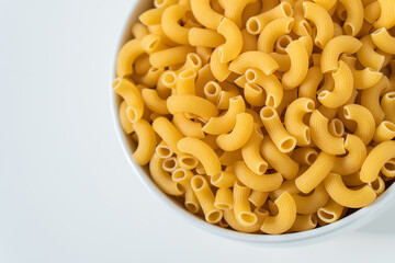 Raw dry uncooked Elbow Macaroni pasta spaghetti on white background. Good for basil tomato pesto sauce Homemade fresh Italian food organic whole wheat vegan spaghetti noodle for a healthy meal