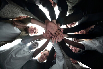 Sticker - bottom view. group of happy young people making a stack of hands