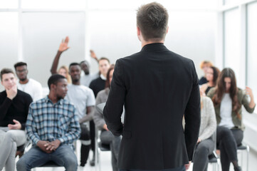 Wall Mural - speaker and a group of diverse young listeners in a conference room