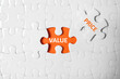 Puzzle with phrase PRICE VALUE on orange background, top view