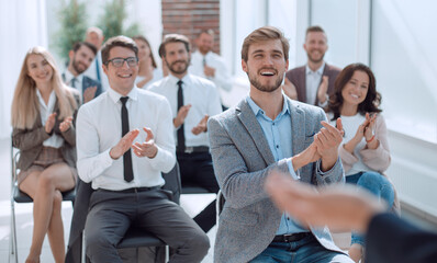 smiling business seminar listeners applauding the speaker