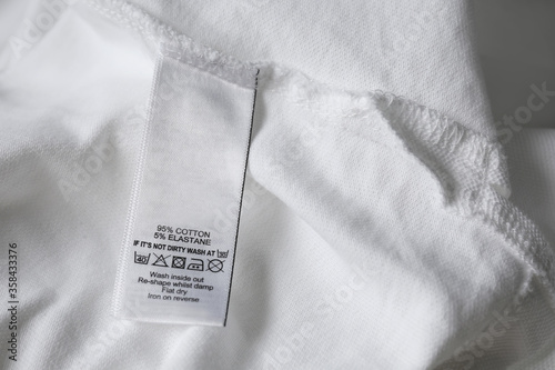 Fotomural Clothing label with care symbols and material content on white shirt, closeup vi