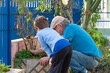 © Alex R. Brondani - Grandfather and grandson cleaning the house garden