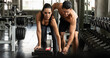 © Mongkolchon - woman workout with dumbbell with trainer in gym and fitness club