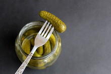 Glass Jar With Pickled Cucumbers And One Strung On A Fork