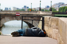 Homeless Man Sleeping Outside On A Stone Alley By The River