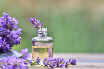  close on purple lavender  flower in a bottle of essential oil on a table in garden
