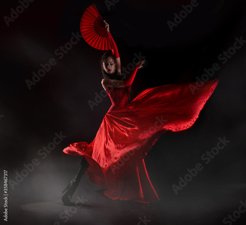 flamenco-woman-spanish-dancer-in-red-dres-performs-with-fan-in-dance-at-black-background-studio-shot