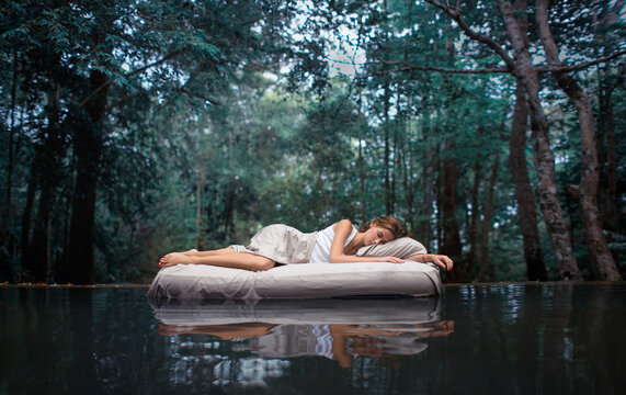 Fototapete -  Sleeping woman in deep forest lies on airbed 