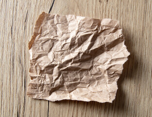 Crumpled paper on a wooden table.