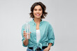 © Syda Productions - people concept - portrait of happy smiling young woman in turquoise shirt holding water in reusable glass bottle grey background