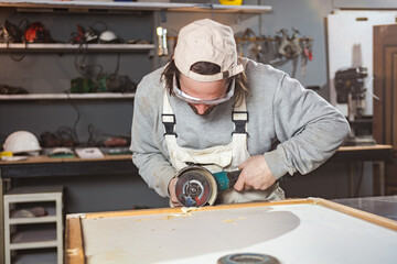 Wall Mural - Male carpenter working on old wood in a retro vintage workshop.