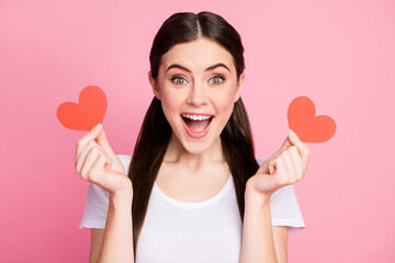 Closeup photo of cheerful lady hold two little red paper postcards romance creative date invitation wear casual white t-shirt isolated pastel pink color background