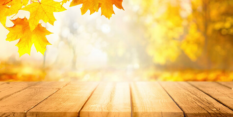 Poster - Beautiful autumn background with orange gold maple leaves on background of sunlight with soft blurred bokeh and empty wooden table planks.