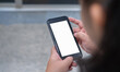 © Jaowfah - The top view of a woman holding a phone with a blank white screen. She played games, sent messages, played social media.Mockup