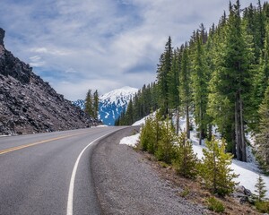 Sticker - Mesmerizing shot of a beautiful snowy rocky road around next to a forest