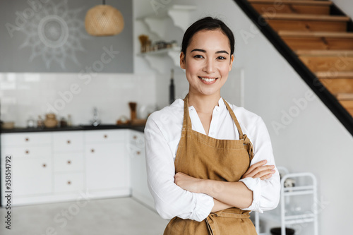 Fotografía Smiling attractive young asian woman wearing apron