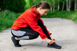 © Yevhenii Rukavitsyn - young girl tying shoelaces before running on a summer forest trail