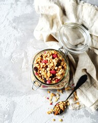 Homemade granola with berries and nuts in a bowl on a gray background