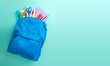 School bag. Backpack with supplies for school on blue background. Copy space for text