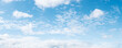 Panoramic blue sky background with small white fluffy clouds, high resolution panorama