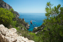 Panoramic View Of The Turquoise Sea With Some Boats From The Mountains Full Of Rocks And Green Bushes Under The Blue Sky At The Calanque De Sugiton In Marseille In France