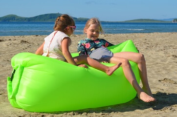 Two sisters relax on the sandy beach at lamzac in the summer lifestyle. happy family on vacation