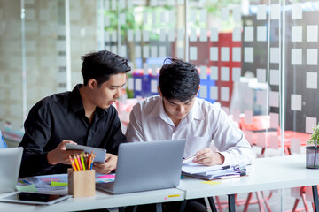 Meeting of young asian business people who are committed to work. Creative business team sitting working together at office.