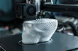 The 3D printer prints white plastic model of skull