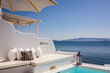 Typical Greek luxury decoration facing the sea to relax with whitewashed walls and comfortable cushions and perfect view on the blue Aeagean Sea in Milos Island in Greece