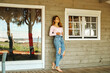 © Cien X Cien Studio/ADDICTIVE STOCK - Calm female in casual jeans standing on wooden veranda of cozy cabin and enjoying hot drink while relaxing and looking away