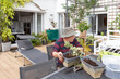 © Inigo Calles/ADDICTIVE STOCK - Side view of senior male pensioner in casual clothes and hat planting seedlings in pot while sitting at table in garden near house