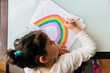 © Manuel Ruiz Alba/ADDICTIVE STOCK - From above girl in casual clothes sitting on chair at wooden table and drawing colorful rainbow with pencil on paper