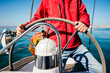 © Manuel Ruiz Alba/ADDICTIVE STOCK - Crop unrecognizable man in red jacket and jeans standing at steering wheel while sailing in sea on modern vessel