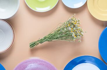 Wall Mural - a bouquet of dried daisies and empty plates.