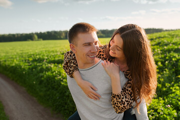 Happy young couple laughing and having fun together outdoors at sunset.