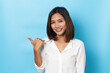 © suriya - Happy asian young woman smiling against made finger thumbs up OK gesture on blue background