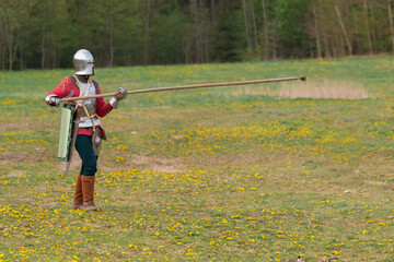 Knights in armor fight on the battlefield. Reconstruction of an ancient battle of the 15th century.