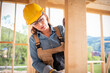 © leszekglasner - Female worker at construction site during work with wood frame house