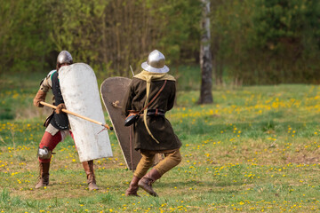 Knights in armor fight on the battlefield. Reconstruction of an ancient battle of the 15th century.