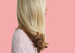 © moodboard - Senior woman with long blonde hair standing over pink background