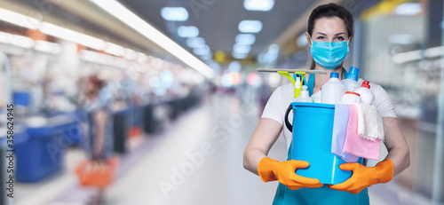 Cuadros en Lienzo A cleaning lady shows a cleaning tool and a cleaning agent .
