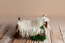 Brown Baby Cot For Newborn Photo Shoot. Props For The Photo Shoot Are Decorated With Fur And Branches