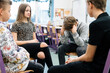 © Photographee.eu - Group of four teenagers sitting together in a circle during psychotherapy session at school
