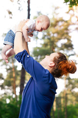 Beautiful blonde mom with he baby in forest,summer time.