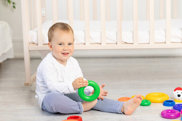 little boy 2 years old playing near the crib, early development